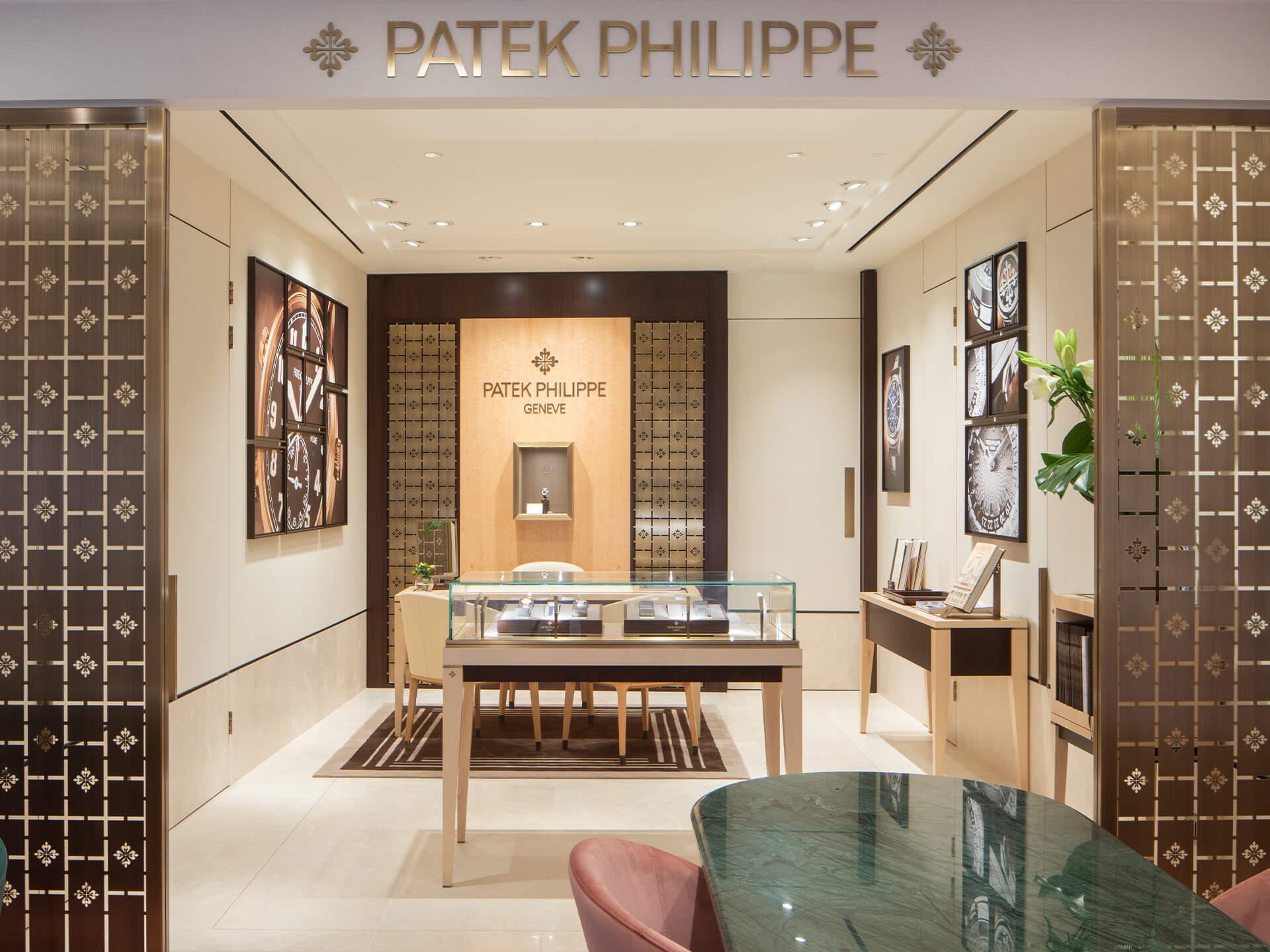 Boodles Liverpool Patek Philippe lounge with a seating area, display cabinets and Patek Philippe photography on the wall.